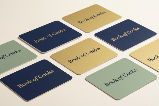 Gift cards with text "Book of Cooks" on them. Cards should be on a clean background, with a modern feel. 